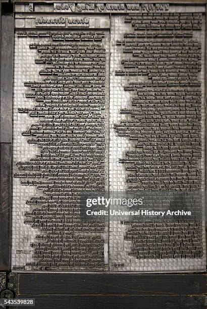 Metal plate with letters set to print a page from a reconstruction of a 16th Century printing press.