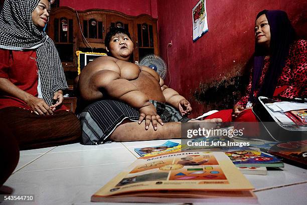 Arya Permana 10-year-old who weights 192 kilograms learning with his teacher in his home on June 13, 2016 in West Java, Indonesia. A 10-YEAR-OLD from...