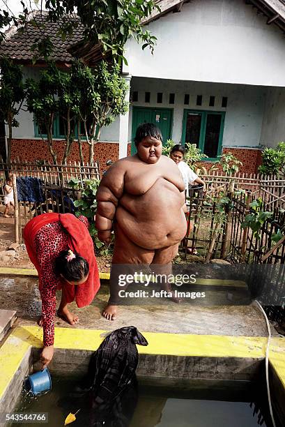 Arya Permana 10-year-old who weights 192 kilograms bath in a small pool in front home on June 13, 2016 in West Java, Indonesia. A 10-YEAR-OLD from...