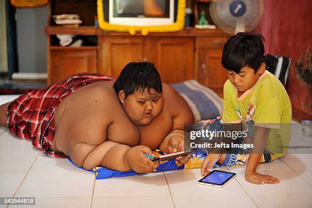 Arya Permana 10-year-old who weights 192 kilograms playing game in his tablet in his home on June 13, 2016 in West Java, Indonesia. A 10-YEAR-OLD...