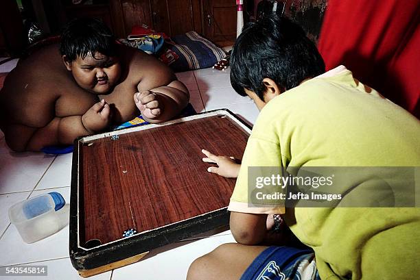 Arya Permana 10-year-old who weights 192 kilograms playing game with his friend in his home on June 13, 2016 in West Java, Indonesia. A 10-YEAR-OLD...