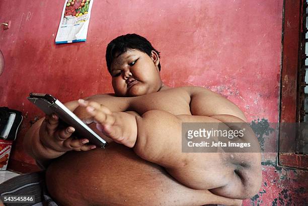 Arya Permana 10-year-old who weights 192 kilograms playing game in his home on June 13, 2016 in West Java, Indonesia. A 10-YEAR-OLD from Indonesia...