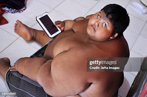 Arya Permana 10-year-old who weights 192 kilograms playing game in his tablet in his home on June 13, 2016 in West Java, Indonesia. A 10-YEAR-OLD...