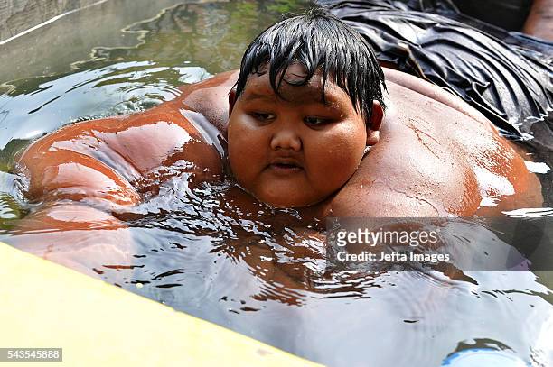 Arya Permana 10-year-old who weights 192 kilograms bath in a small pool in front home on June 13, 2016 in West Java, Indonesia. A 10-YEAR-OLD from...