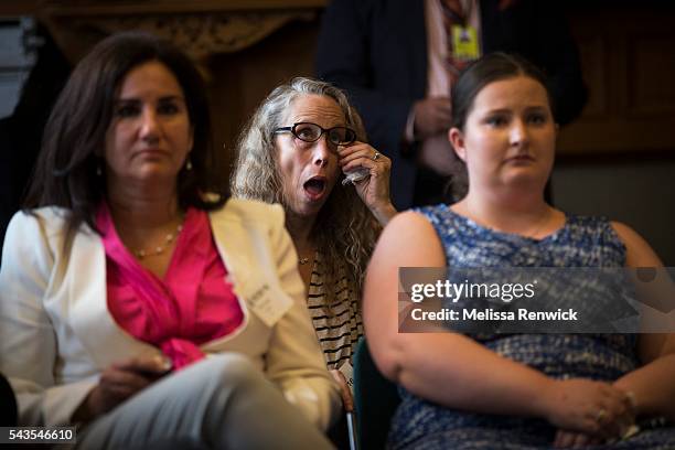 Gal Geller, who is the mother of a 20-year-old man with Autism wipes away her tears as the Minister of children and youth services, Michael Coteau,...