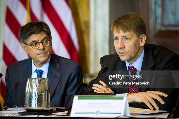 Treasury Secretary Jacob J. Lew looks on as Director of the Consumer Financial Protection Bureau, Richard Cordray delivers remarks during a public...