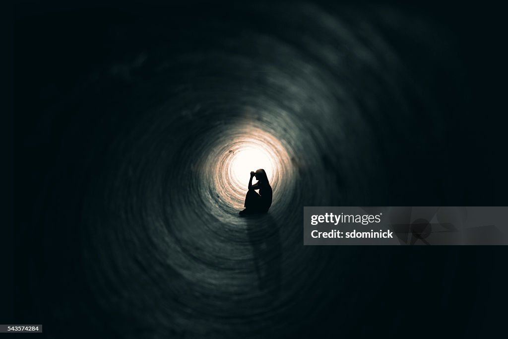 Woman Praying In A Dark Place