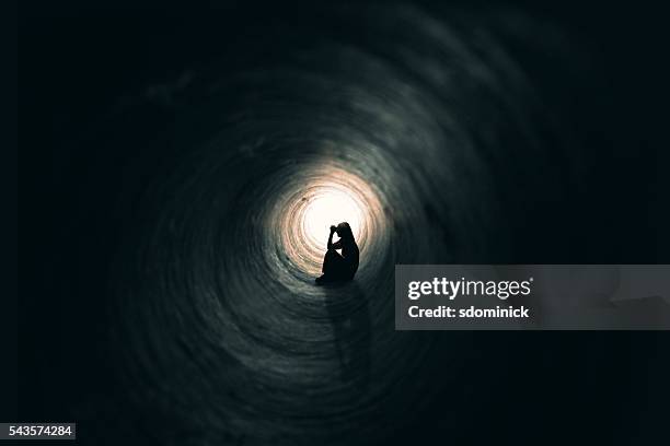 woman praying in a dark place - alone bildbanksfoton och bilder