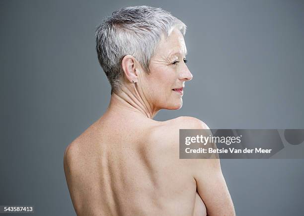 senior woman with shirtless back turned to camera. - cheveux blancs photos et images de collection