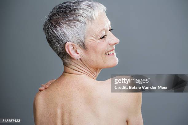 senior woman with bare shoulders smiling. - beautiful bare women fotografías e imágenes de stock