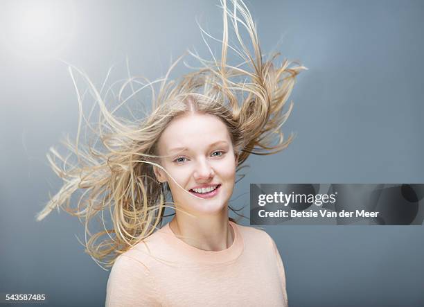 young woman tossing her  flowing long hair - hair blowing stockfoto's en -beelden