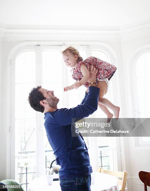 a 2 years old girl in the arms of her daddy - men wearing dresses stock-fotos und bilder