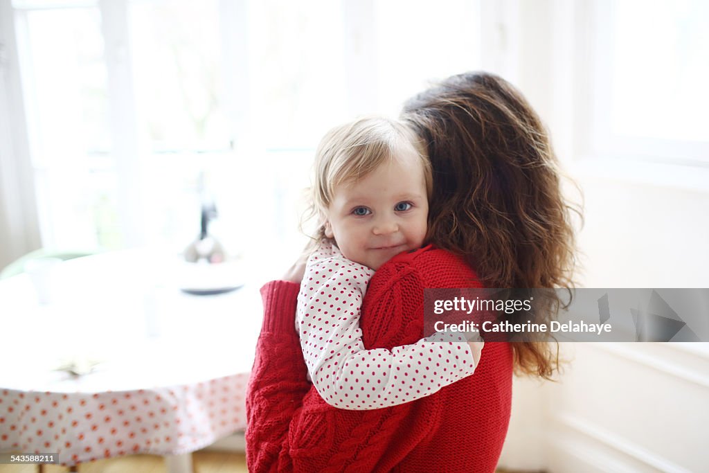 A 2 years old girl in the arms of her mum