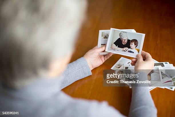 senior woman looking at a photo - só uma mulher idosa imagens e fotografias de stock