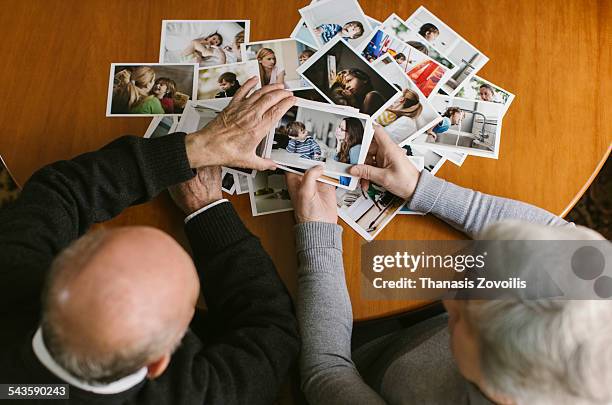 senior couple looking at photos - waist up photos stock-fotos und bilder