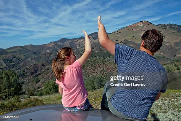 father and daughter high fiving on car - サンタイネス ストックフォトと画像