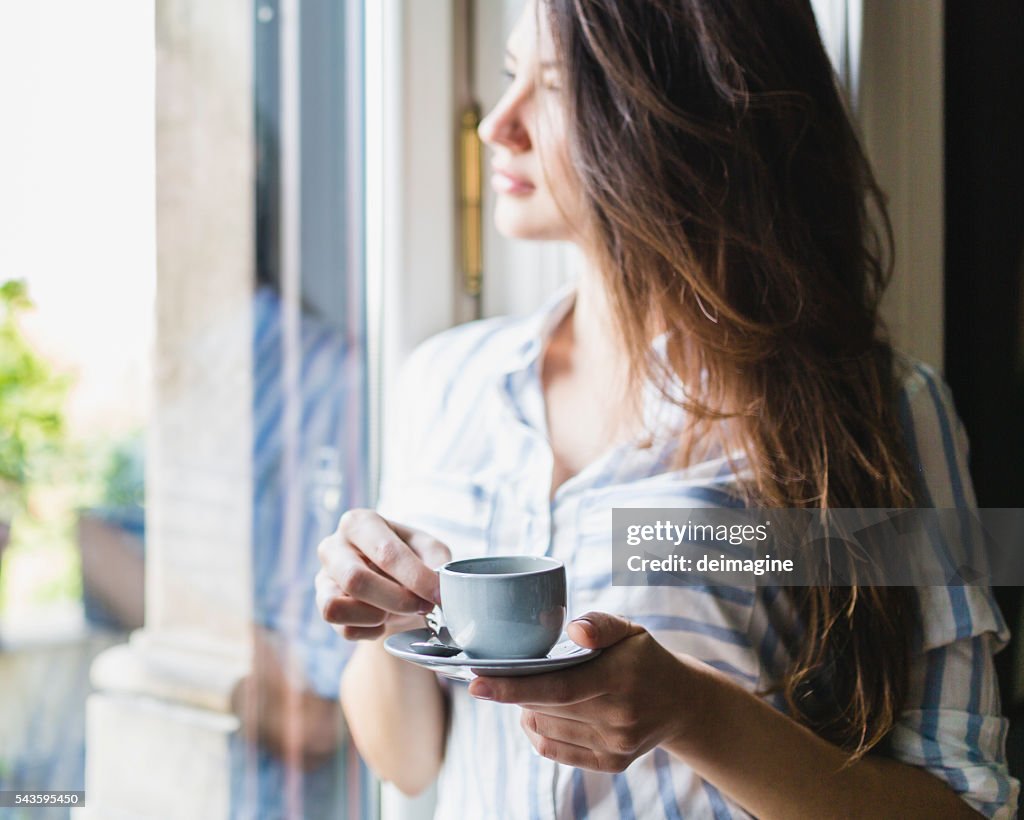 Woman drinks coffee at home