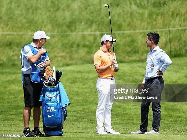 Rory McIlroy of Northern Ireland looks on with his caddie J.P. Fitzgerald and agent Sean O'Flaherty during a pro-am round ahead of the 100th Open de...