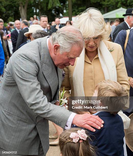 Prince Charles, Prince of Wales and Camilla, Duchess of Cornwall are presented with flowers by two chldren during their visit to The Royal Norfolk...