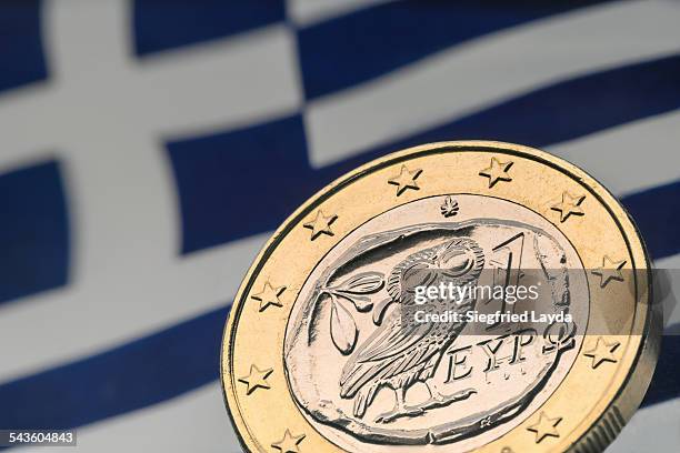 greek euro coin and flag - griechische geldmünze stock-fotos und bilder