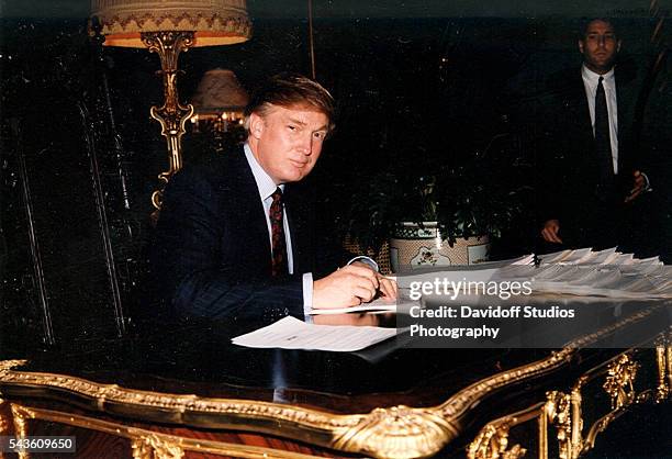 Portrait of American businessman Donald Trump as he signs documents at a desk in the Mar-a-Lago estate, Palm Beach, Florida, 1995.