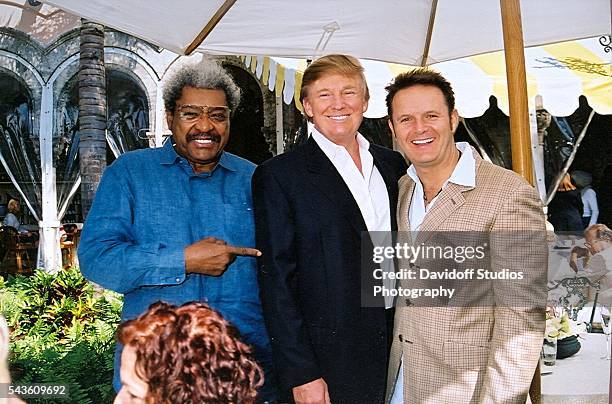 Group portrait of, from left, American boxing promoter Don King, businessman Donald Trump, and television producer Mark Burnett as they pose together...