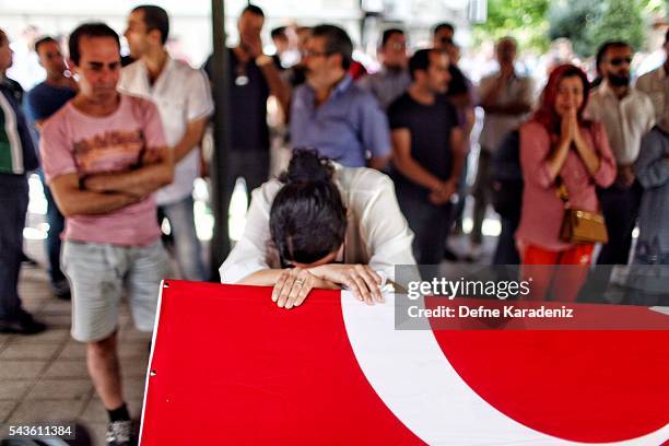 Relatives of 27-year-old flight officer Gulsen Bahadir, a victim of yesterdays attack on Istanbul Ataturk airport, mourn at her Turkish flag-draped...