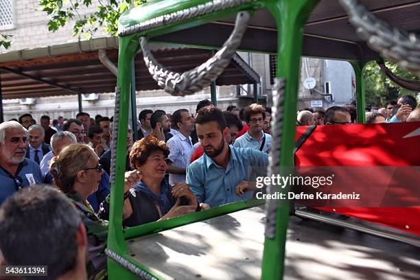 Relatives of 27-year-old flight officer Gulsen Bahadir, a victim of yesterdays attack on Istanbul Ataturk airport, mourn at her Turkish flag-draped...