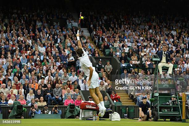 Switzerland's Roger Federer leaps to return a lob from Britain's Marcus Willis in their men's singles second round match on the third day of the 2016...