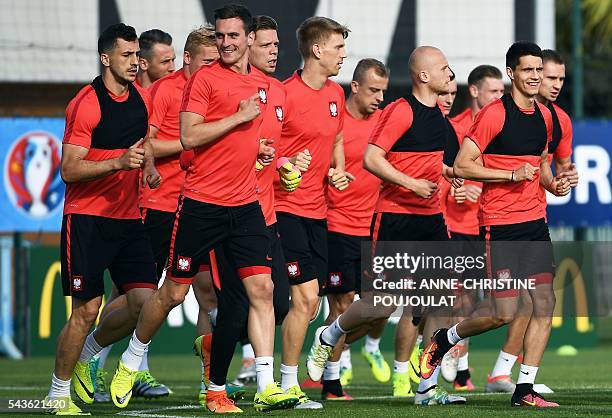 Poland's forward Arkadiusz Milik runs with teammates during a training session at the Robert-Louis-Dreyfus stadium in Marseille, southeastern France,...