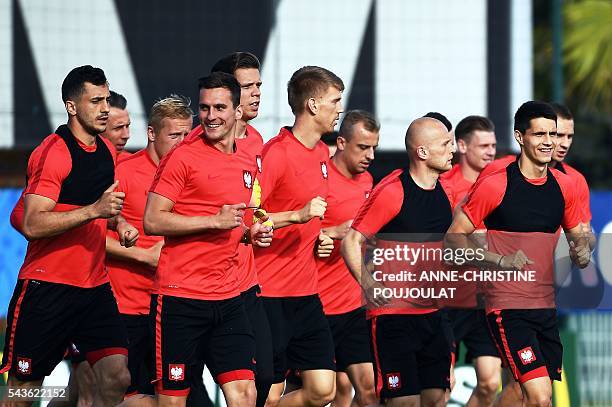 Poland's forward Arkadiusz Milik runs with teammates during a training session at the Robert-Louis-Dreyfus stadium in Marseille, southeastern France,...