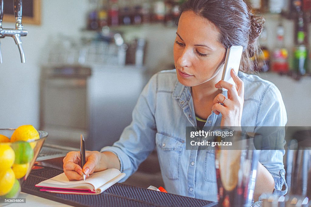 Young, casual female bar owner ordering merchandise