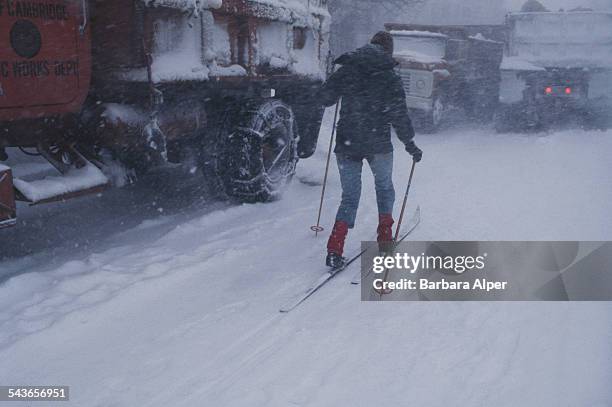 Woman cross country skiing next to snow ploughs in Cambridge, Massachusetts, during the 'Blizzard of '78', February 1978.