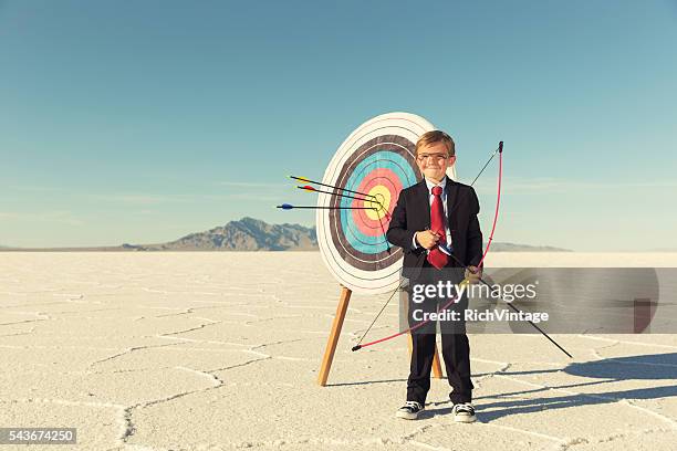 young boy and business archer with target - target stockfoto's en -beelden