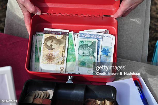 Woman showing the day's earning from the sale of homemade cakes at the market day.