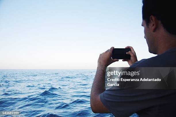 Young man take a picture with a smartphone to the sea