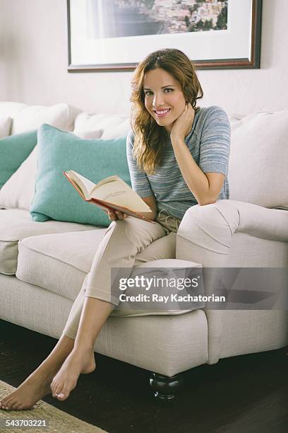 young woman reading book smiling - legs crossed at knee stock pictures, royalty-free photos & images