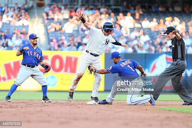 Elvis Andrus of the Texas Rangers applies the tag late on a pick-off play on Jacoby Ellsbury of the New York Yankees in the first inning at Yankee...