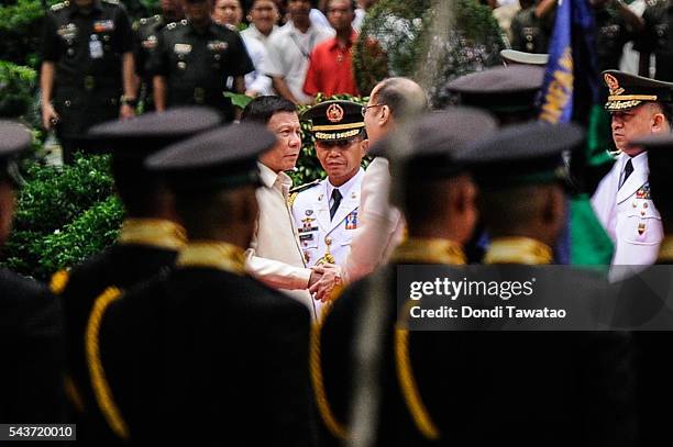 President-elect Rodrigo Roa Duterte and outgoing president Benigno Aquino III shake hands during the inauguration at Malacanang Palace on June 30,...