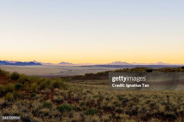 desert landscape in namibia with sunrise in the distance - ignatius tan stock pictures, royalty-free photos & images