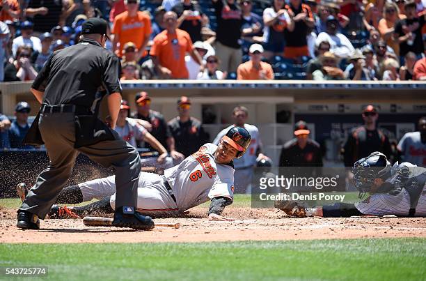 Jonathan Schoop of the Baltimore Orioles scores ahead of the tag of Derek Norris of the San Diego Padres during the fifth inning of a baseball game...