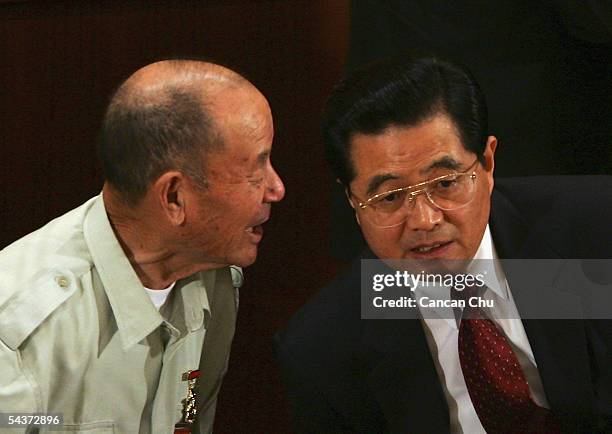 Chinese President Hu Jintao talks with Chen Zhonglai, a war veteran during a meeting marking the 60th anniversary of the victory of China's...