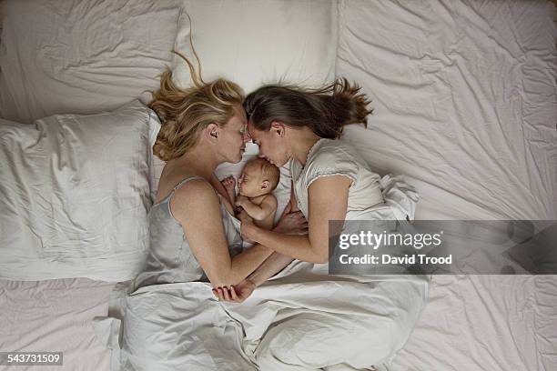 lesbian couple with baby boy - lesbian bed stock pictures, royalty-free photos & images