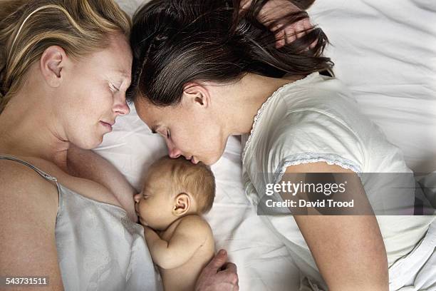 lesbian couple with baby boy - gay couple sleeping fotografías e imágenes de stock