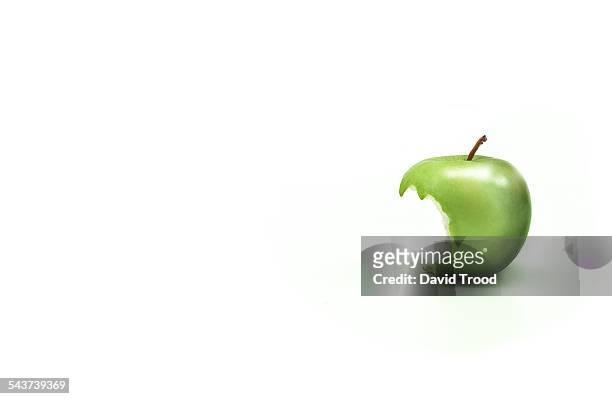 apple with a bite taken out of it. - apple bite out stock pictures, royalty-free photos & images