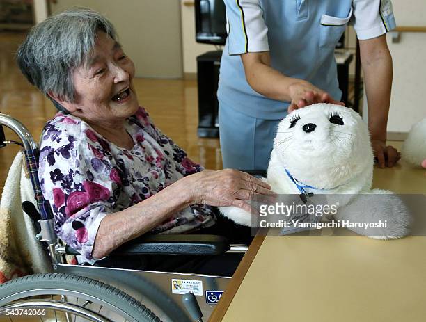 Resident of a nursing home plays with nursing-care robot 'Paro' at the nursing home in Yokohama city, Kanagawa prefecture, Japan Oct. 9, 2013. PARO...