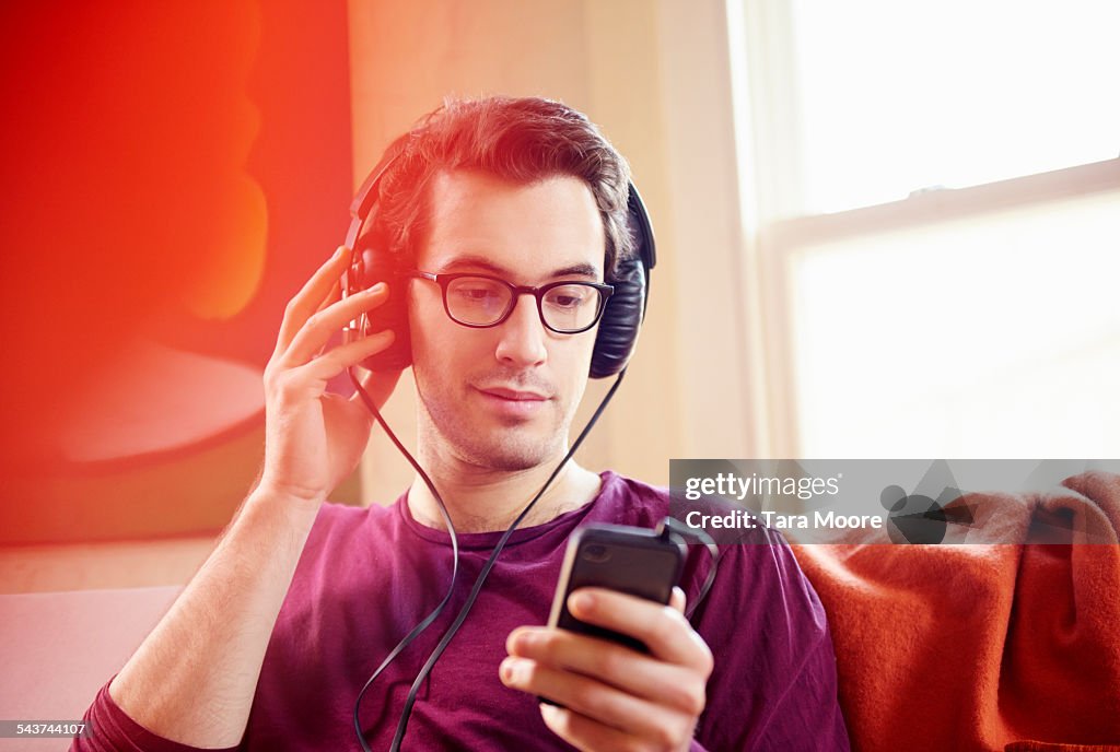 Young man with headphones and mobile at home