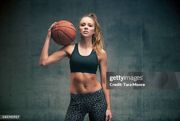 female athlete with basketball concrete background - sports equipment foto e immagini stock