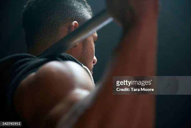male athlete lifting weight bar black background - man stoer stockfoto's en -beelden