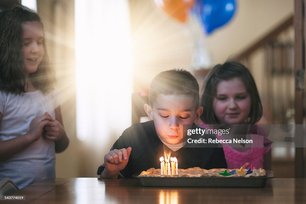 Boy blowing out birthday candles